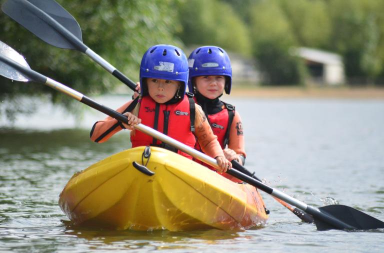 two kids on a double kayak