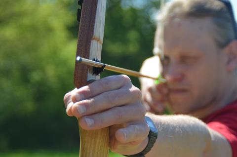 man taking aim with a bow and arrow